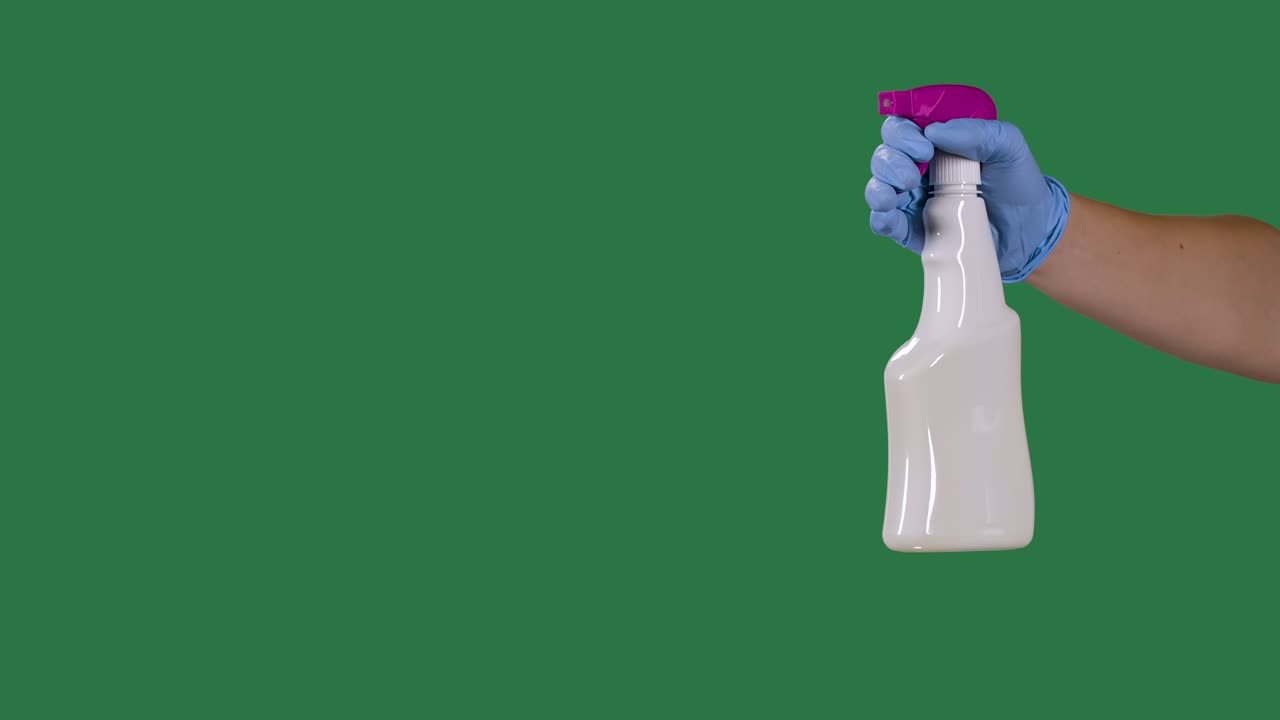 hombre con guantes de protección pulveriza un spray higiénico de limpieza para la desinfección y prevención de covid-19. pantalla verde, llave de croma. cámara lenta. primer plano