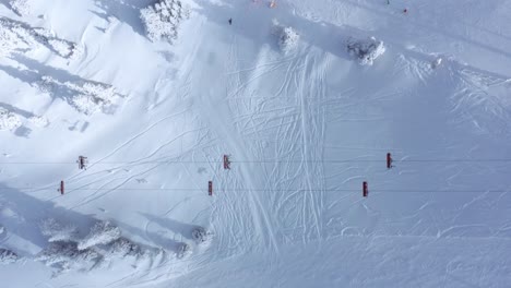 Wide-snow-covered-hill-with-ski-lift-with-people