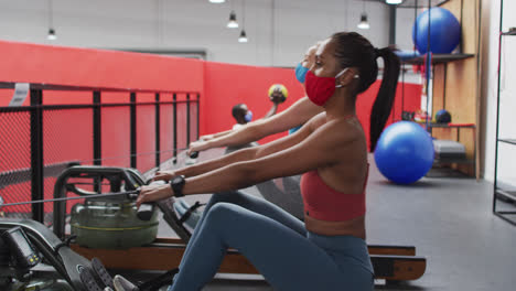 grupo diverso con máscaras faciales haciendo ejercicio en el gimnasio