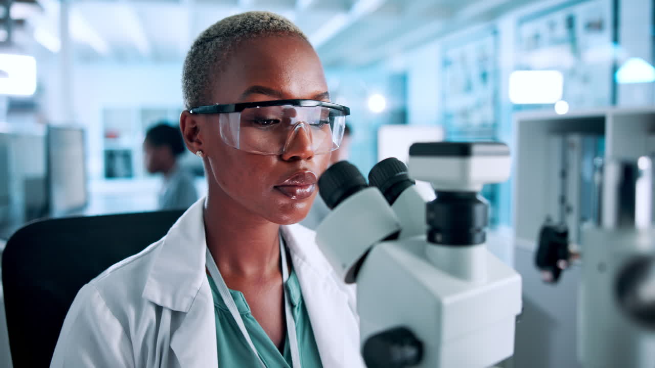 Scienziata che usa il microscopio in laboratorio