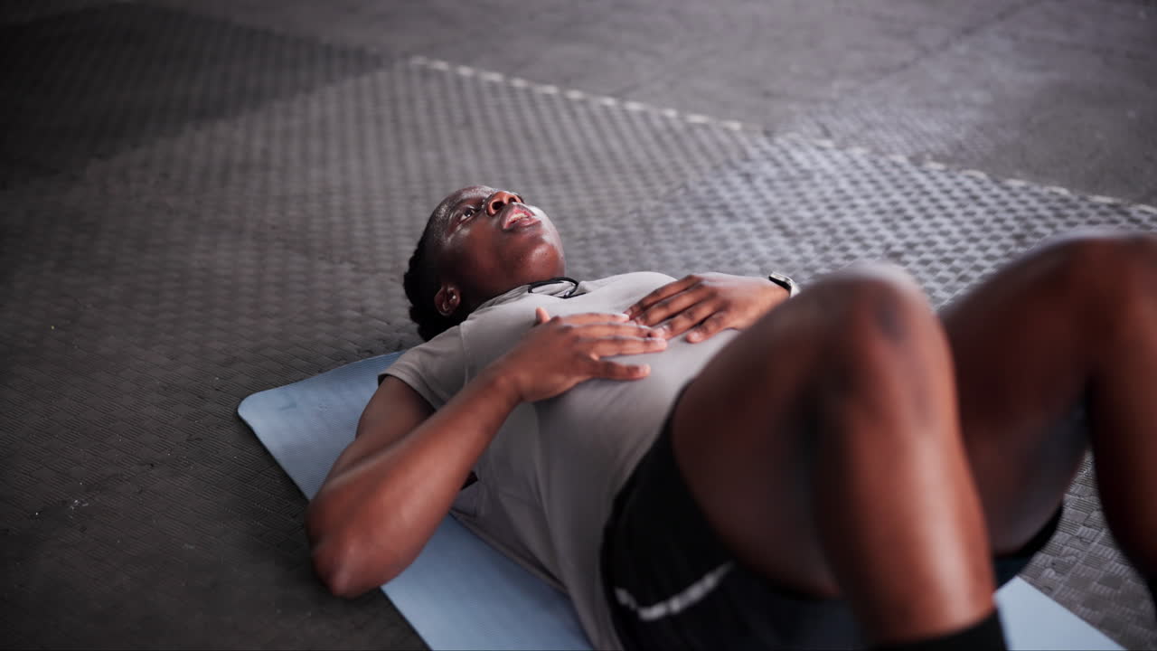 hombre haciendo abdominales en una alfombra de gimnasio