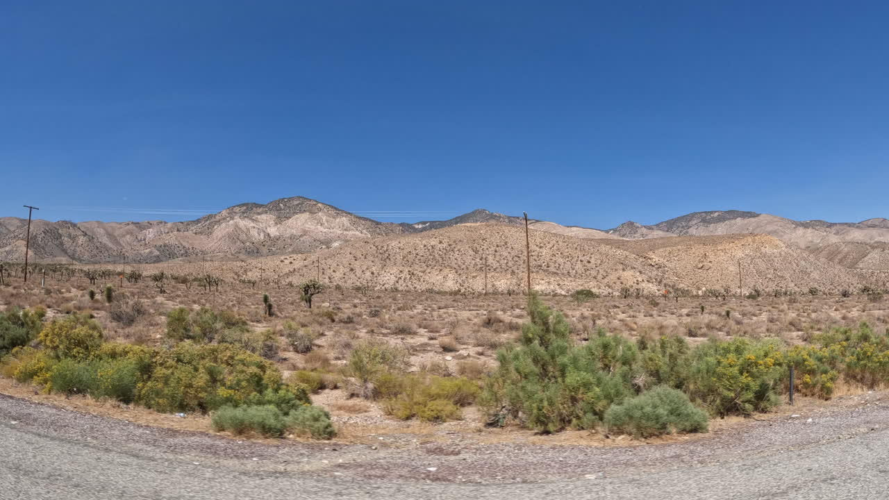 Guardando fuori dal finestrino del passeggero in un'auto che attraversa il deserto del Mojave.