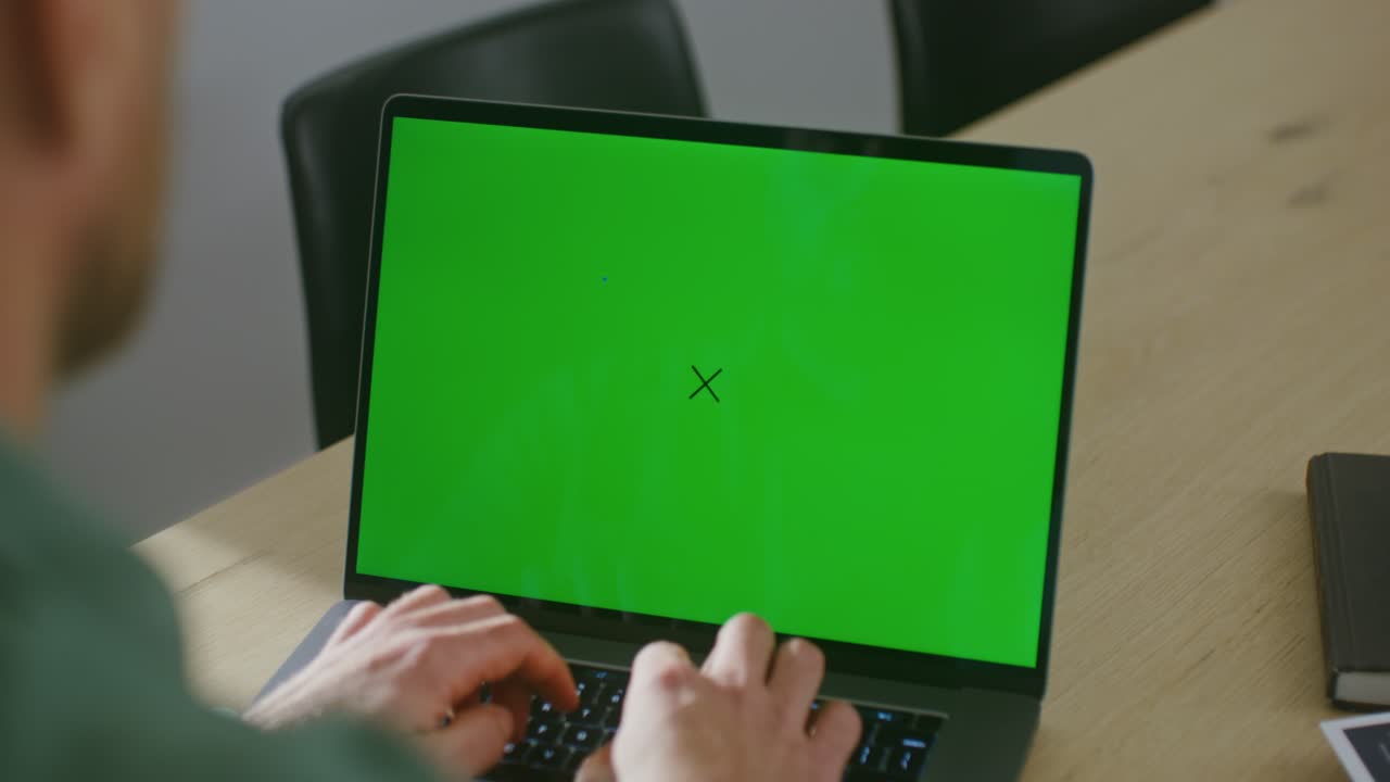 persona que trabaja en una computadora portátil con pantalla verde