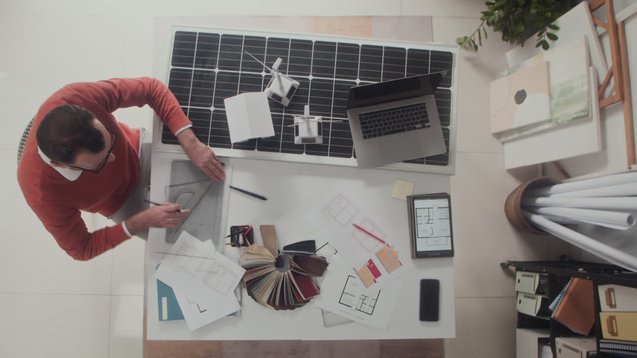 View from above on Architect Working at Office Table with Blueprint