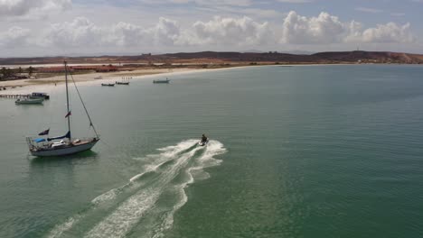 Drone-follow-up-skyjet-driving-fast-on-water-in-Coche-Island,-Venezuela