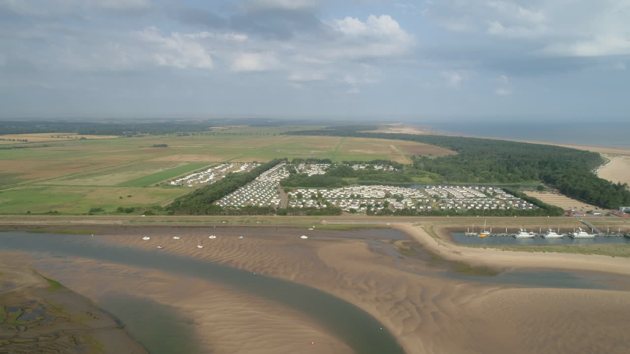 범선 wells-next-the-sea 북부 노퍽 영국 동부 해안과 함께 썰물 때 해안 마을 정적 캐러밴 주택과 크릭의 돌리 슬라이더 샷 설정