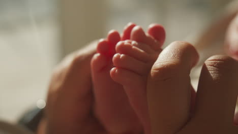 tender moment of mother holding newborn's tiny feet