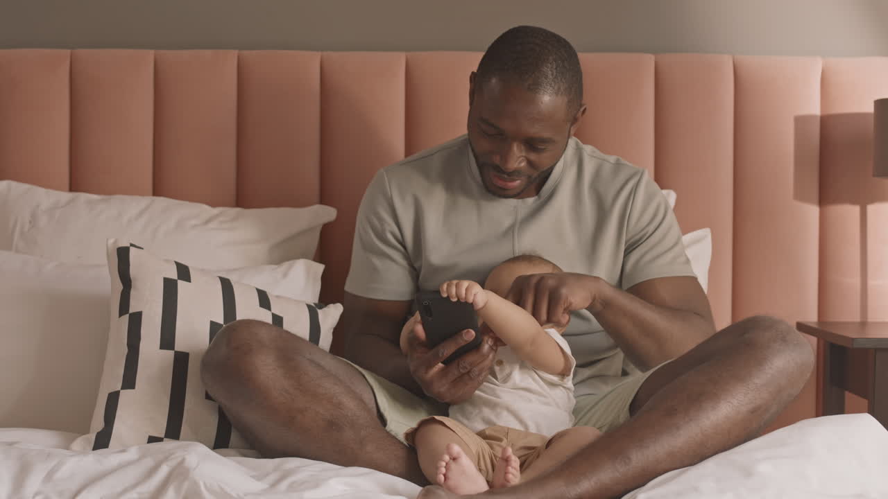 Man Teaching Toddler Using Smartphone
