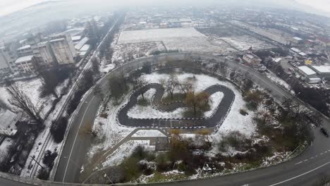 aerial view, passing an overpass, eastern european town on a cloudy and snowy day