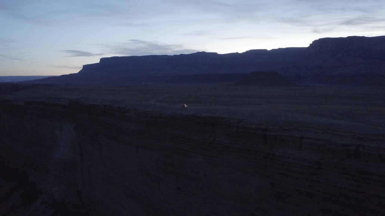 panorama aéreo, mini autocaravana estacionada junto al acantilado del cañón rojo del cañón de mármol en arizona al atardecer