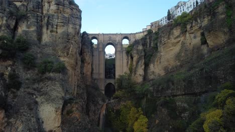 Ancient-arch-bridge-of-Ronda-city-in-Spain,-aerial-drone-fly-toward-view