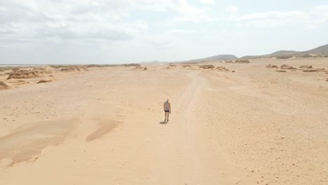 walking in the desert, drone follow person from behind, sand dunes guajira colombia