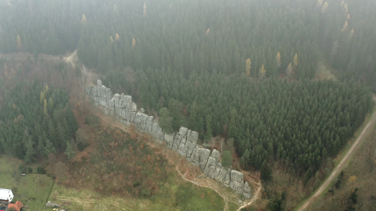 toma aérea sobre las nubes de una pared de roca en un impresionante paisaje forestal, destino natural