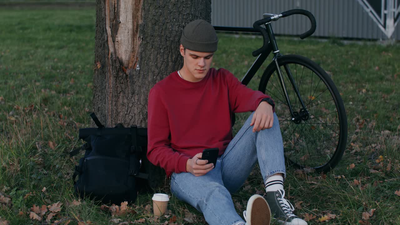 Young Man Relaxing in Park with Bicycle