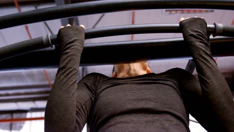 mujer haciendo pull-ups en un estudio de fitness 4k