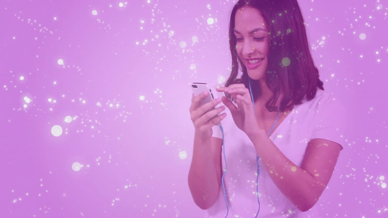 Woman tapping phone screen and adjusting earbud, nodding to music on pink gradient sparkle overlay