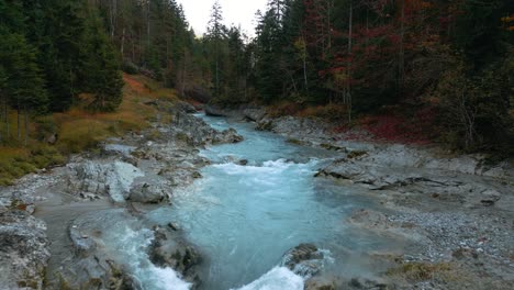 slow motion mountain river waterfall canyon with fresh blue water in bavaria austria alps, flowing along a forest and trees near sylvenstein speicher and walchensee