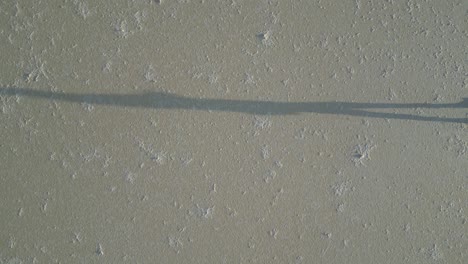 shadow silhouette of walking person on dried salt lake in western australia