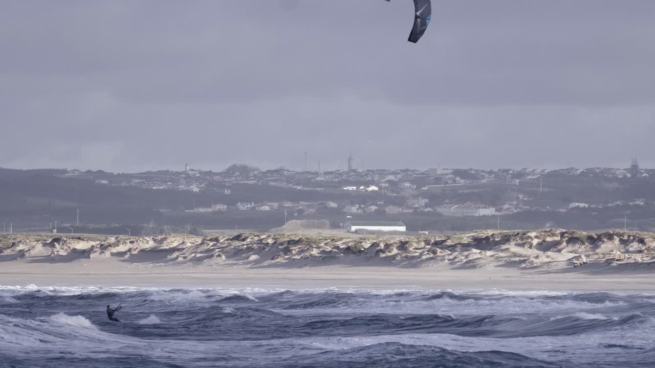 Kiteboarding eller kitesurfing på barske havbølger i Peniche, Portugal, enkeltpersonsudsigt.