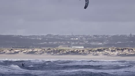 kiteboarding or kitesurfing on rough ocean waves in peniche, portugal, one person view