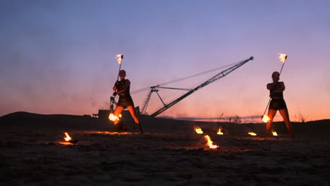 fire show. a group of professional artists performs a variety of fire facilities. boys and girls performed dances with fire in the night on the street in the park.