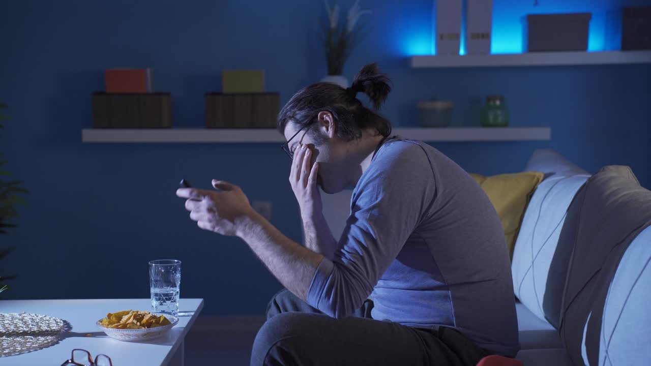 Funny man crying while watching tv.