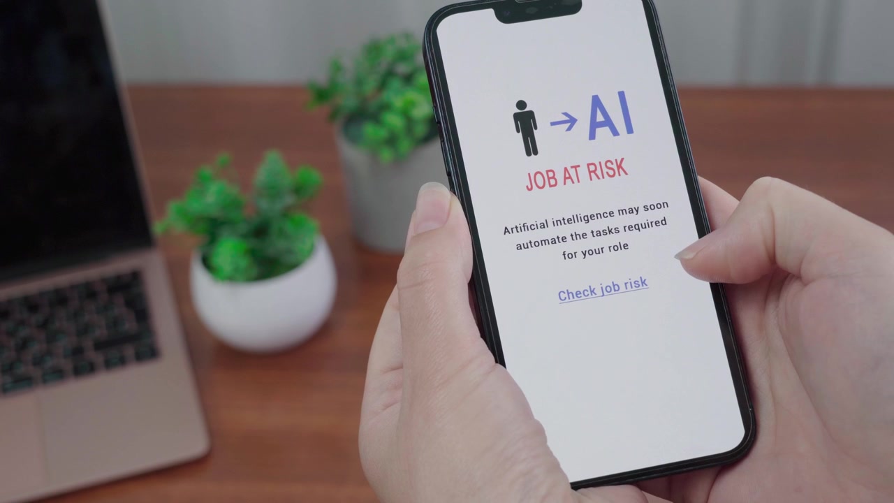 Hands hold a phone as an AI job risk app warns that artificial intelligence may soon automate the viewer's role.