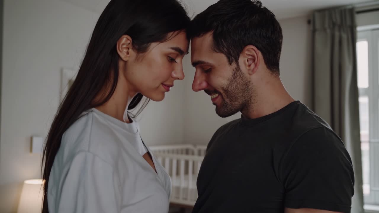 Romantic couple standing face to face, foreheads gently touching, cherishing a moment of intimacy and connection within the cozy comfort of their home