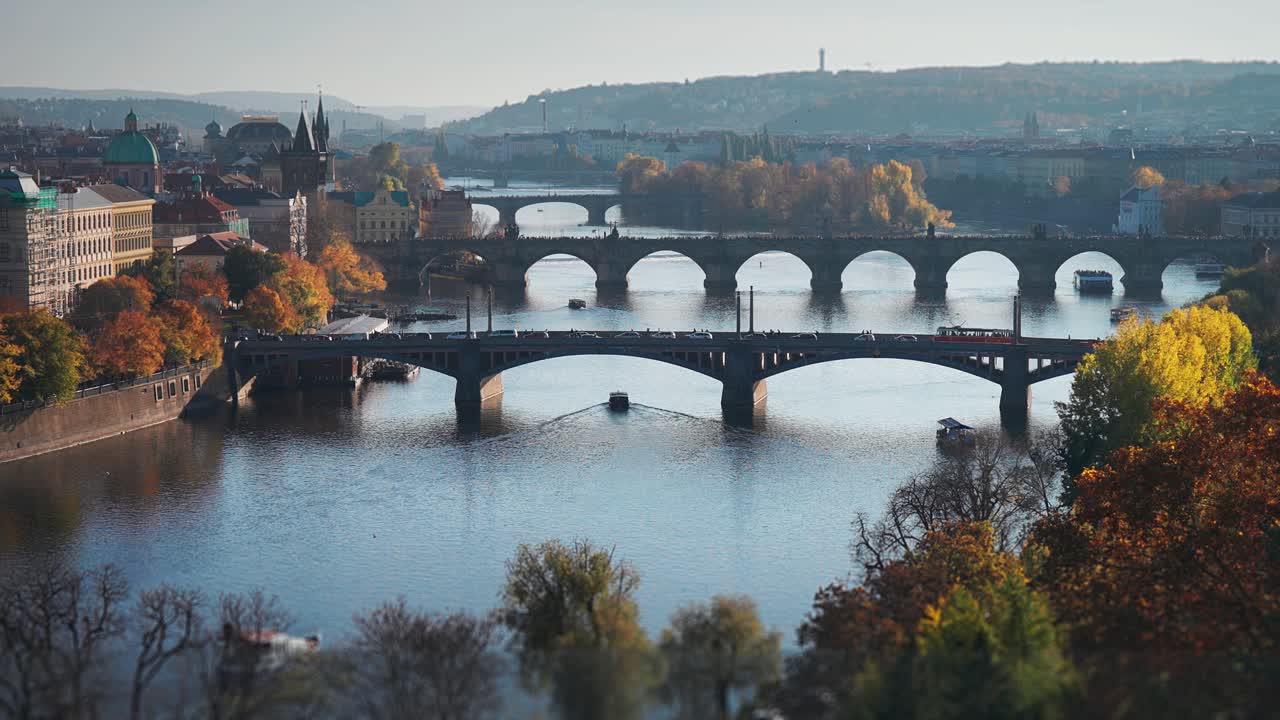A serene view of Prague’s Vltava River with its famous bridges under soft autumn sunlight. A timelapse video.
