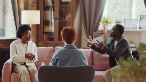 pareja afroamericana peleando y escuchando al terapeuta familiar
