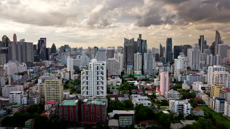 aerial trucking view of bangkok cityscape skyline under dramatic sunset sky