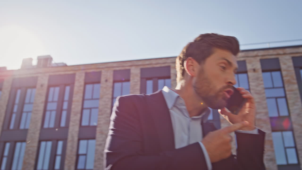 Capo furioso che discute al telefono in primo piano in un quartiere urbano. Uomo d'affari arrabbiato che chiama