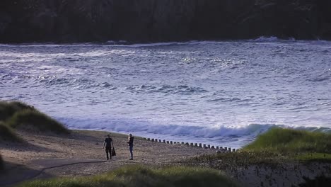 golden hour footage of a couple walking along dalmore beach near carloway