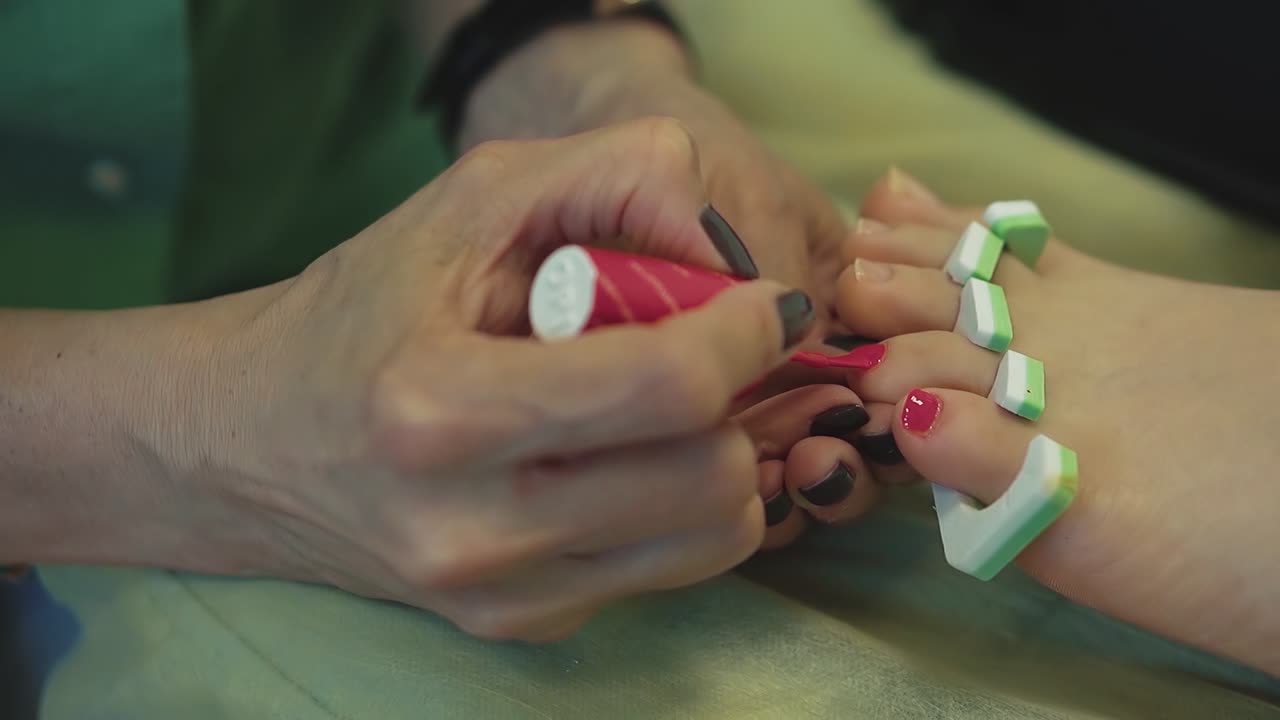 closeup pedicurist paints young woman toenails 2