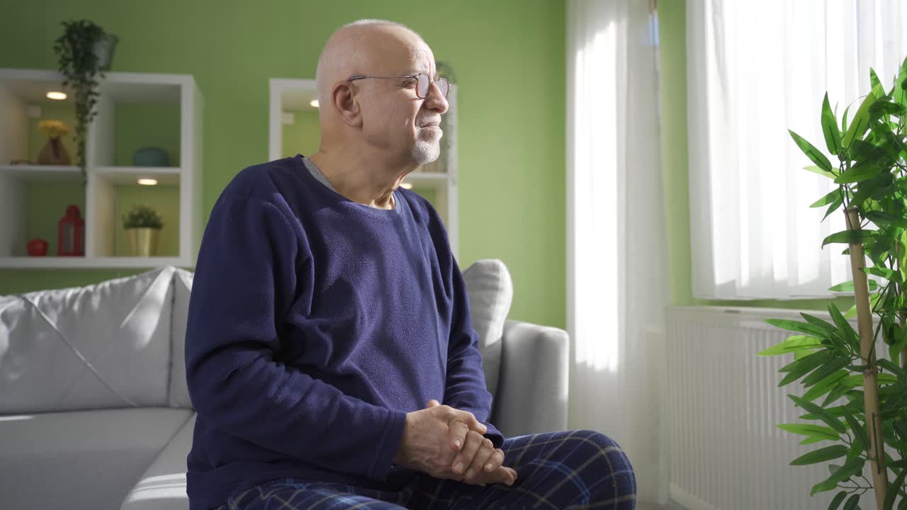 Uomo in pensione frustrato che guarda fuori dalla finestra, pensando ai problemi personali.