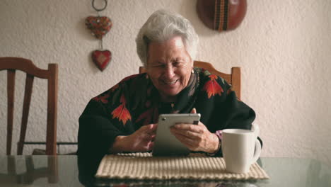 aged woman with gadget sitting at table