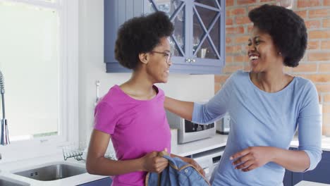 Feliz-Madre-E-Hija-Afroamericana-Sonriendo-Y-Abrazándose-En-La-Cocina