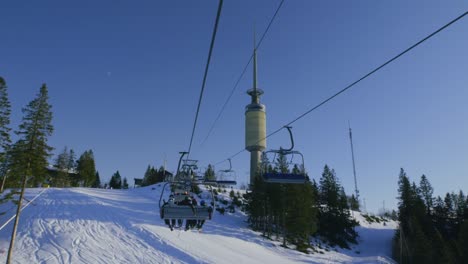 main chairlift at oslo vinterpark with skiers, tryvann tower, winter park ski resort