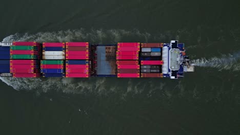 container vessel loaded with containers sailing fast on a dutch river