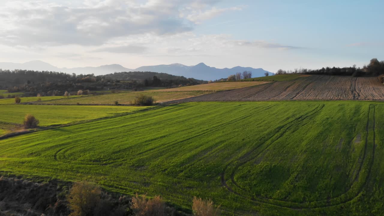 Drone Video over mountain farm fields sunset Blue backround peaks distance