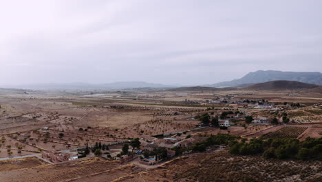 Drone-capturing-beautiful-view-of-a-large-dry-grassland,-landscape-outside-of-a-city-in-Spain,-Murica