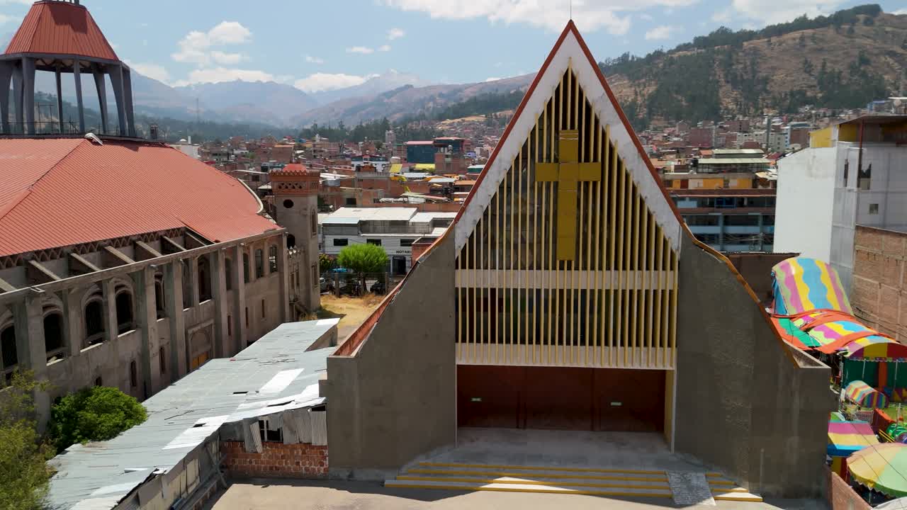 Sagrario de San Sebastián Cathedral in Huaraz, Peru, showcasing its unique modern architecture against the backdrop of the city and the Andes mountains - A dynamic aerial parallax shot