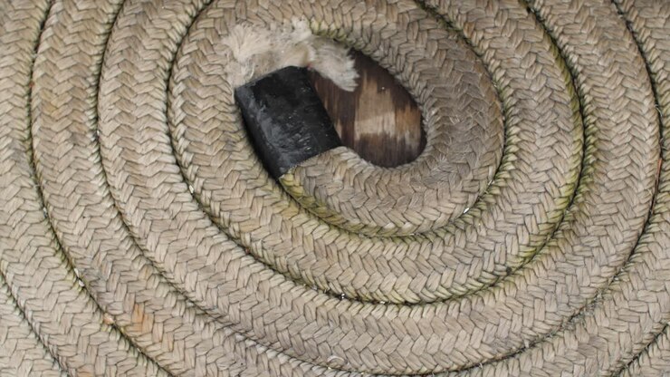 Primo piano di una cima a spirale sul ponte di una barca a vela.