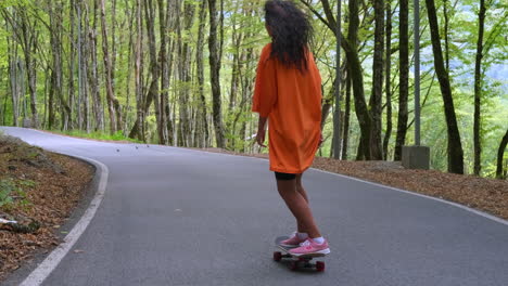 chica patinando en un camino del bosque