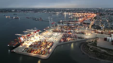 Aerial-of-Montevideo-capital-city-of-Uruguay-illuminated-at-night-cargo-ship-on-commercial-port-harbor