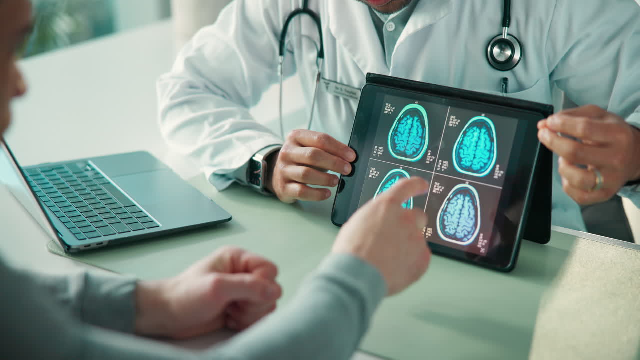Doctor Explicando Escáneres Cerebrales en Tableta a un Paciente