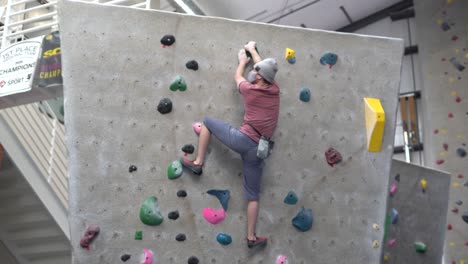 Rock-climber-climbing-an-indoor-rock-wall-using-athletic-chalk-for-grip-10