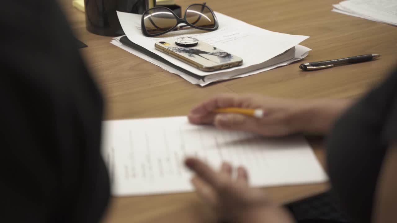 dette er en person, der skriver i en engelsk klasse, mens hun tager noter og samarbejder med sine klassekammerater