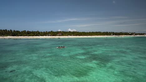 aerial view of tropical beach with people in boat