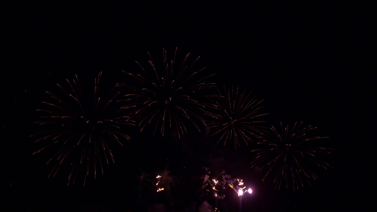 Celebratory fireworks in the distance fill the night sky